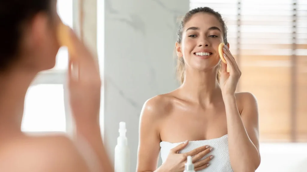 Mujer haciendo la rutina de cuidado de la piel facial de pie cerca del espejo